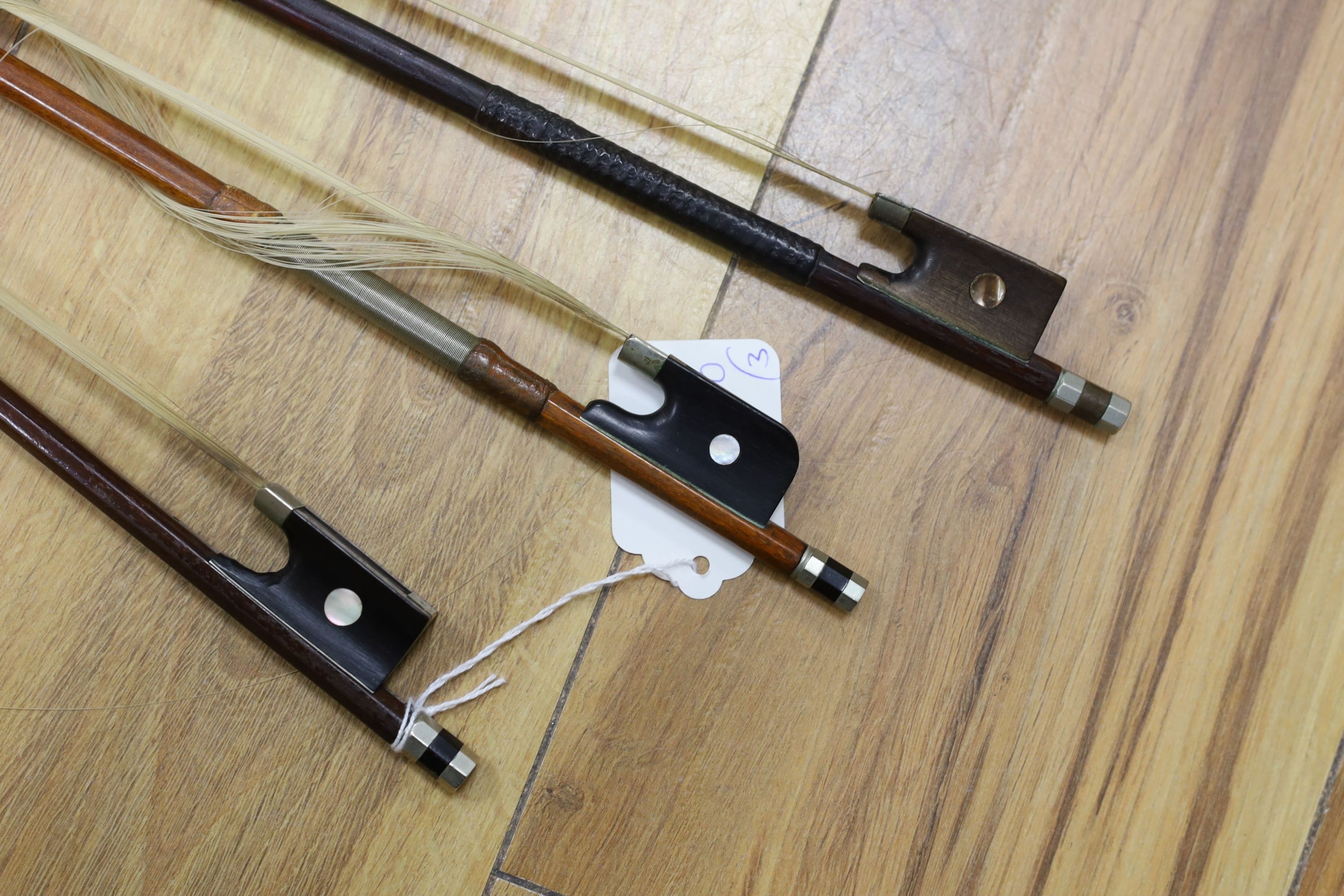 Three nickel mounted violin bows, one stamped R. R. Shields, two with ivory veneered tip - longest 75cm